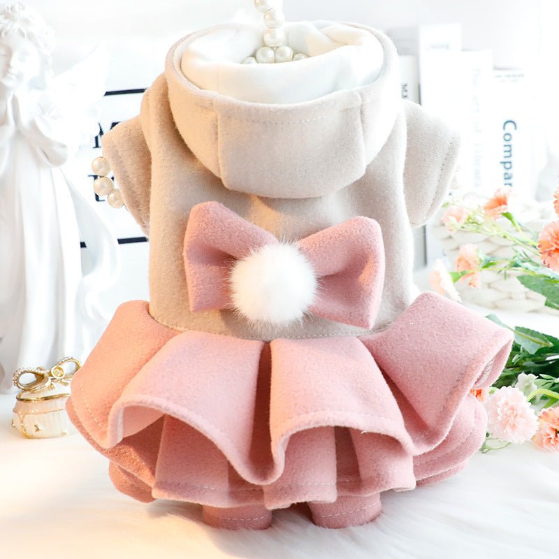 Front of the pink layered dog dress with its hood and pom-pom bow