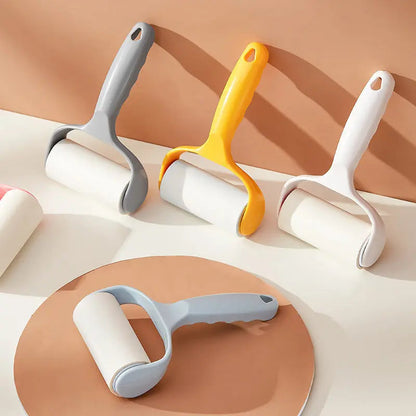 Gray, yellow and white lint rollers for pet hair standing on a table with one lying flat.