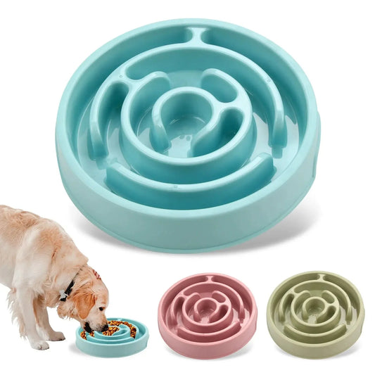 Blue maze slow feeder dog bowl with a golden retriever eating from it and pink and green bowls beside it.