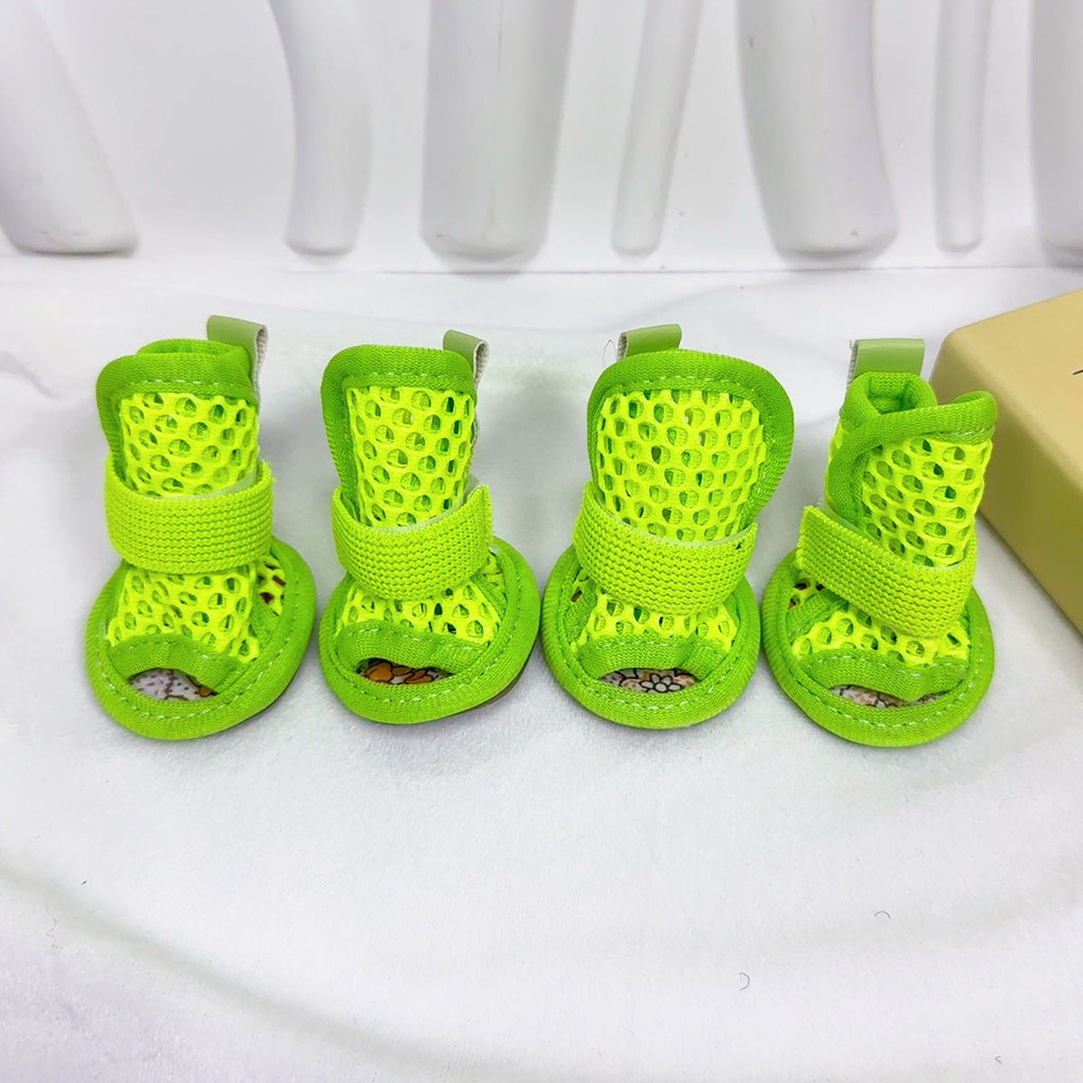 Set of four green Noblias mesh dog sandals with matching elastic straps.