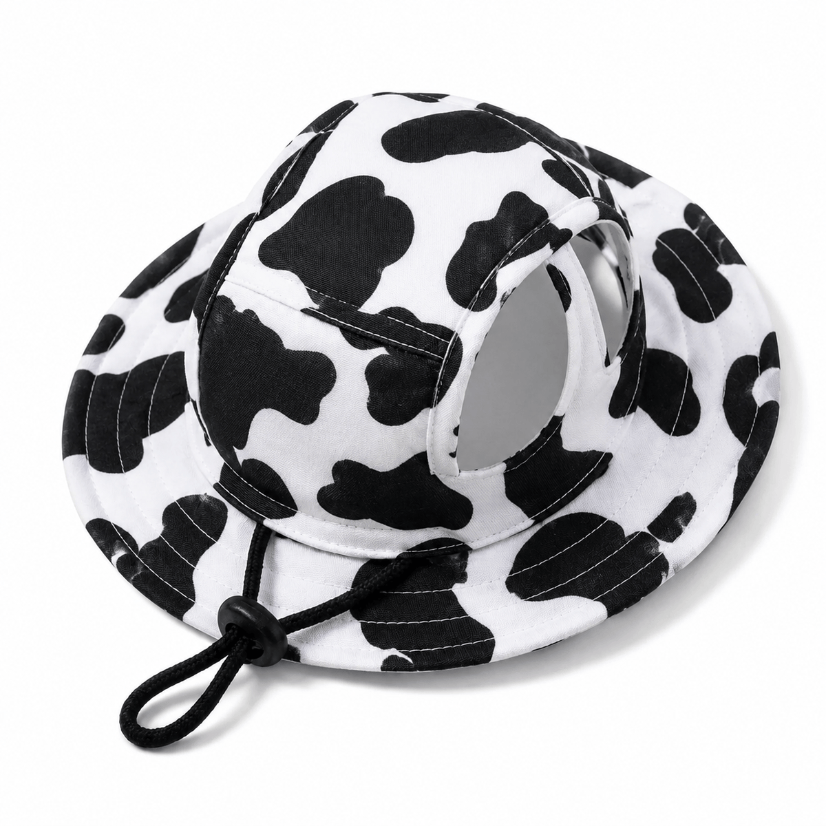 The black and white cow print hat photographed alone on a white background with the chin cord hanging loose.