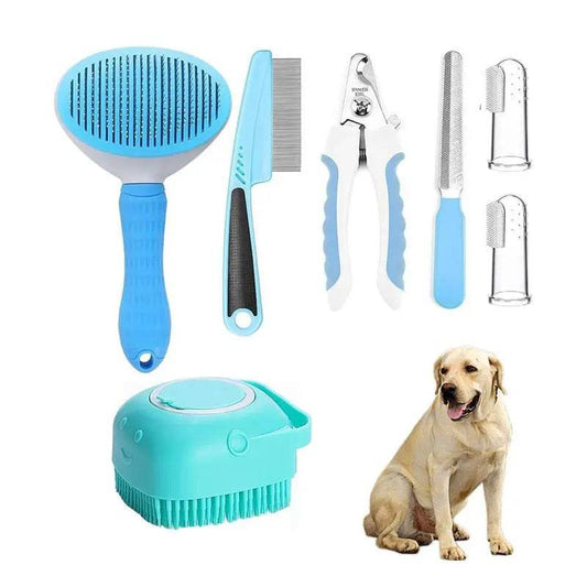 The six-piece pet grooming kit laid out: blue slicker brush, flea comb, nail clipper, nail file, two finger toothbrushes and a teal shampoo bath brush, beside a labrador.