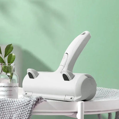 White reusable pet hair remover brush on a side table beside a gray knit blanket.