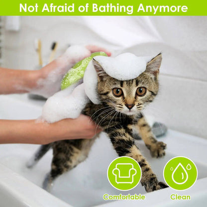Kitten covered in foam in a bathtub beside the green pet steam brush, captioned not afraid of bathing anymore.
