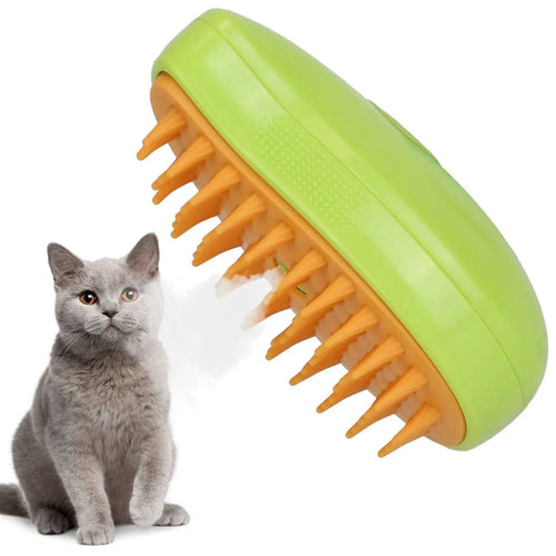 Green pet steam brush with orange silicone teeth releasing a fine mist beside a gray cat.
