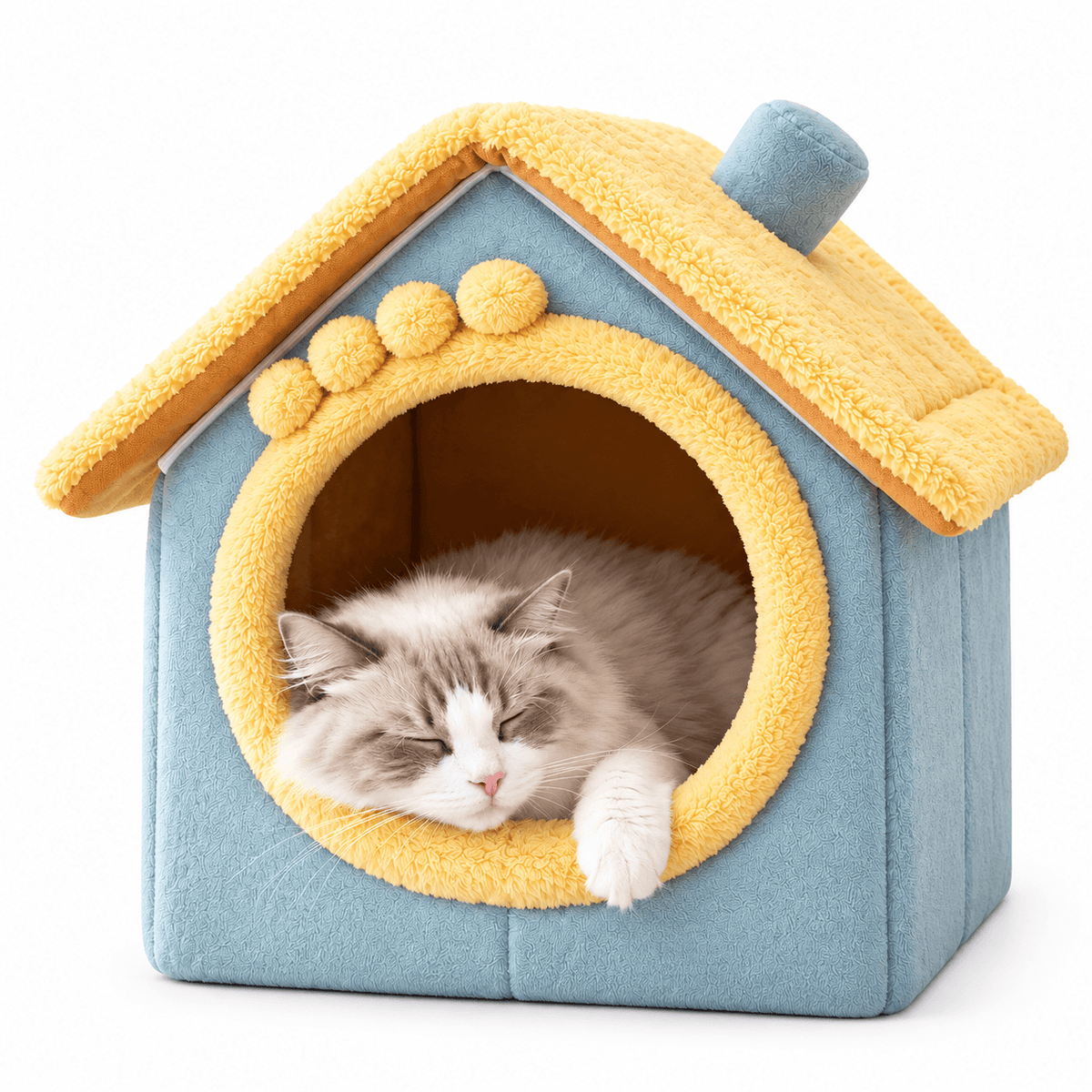 Yellow roof and blue plush cat house bed with pom-pom trim and a fluffy cat napping in the doorway.