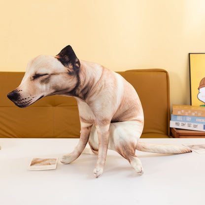 Funny pooping dog plush toy sitting on a table in front of a tan sofa, seen from the front.