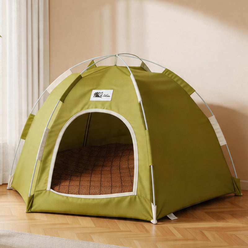 Olive green pop up cat tent bed on a wooden floor with a bamboo mat inside.