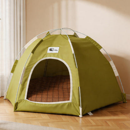 Olive green pop up cat tent bed on a wooden floor with a bamboo mat inside.