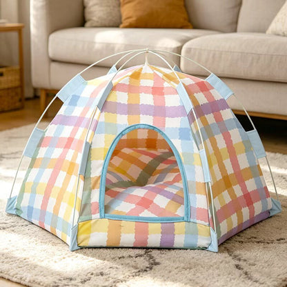 Pastel plaid pop up cat tent bed on a rug in a living room with a cushion inside.
