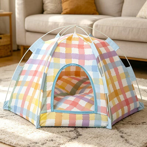 Pastel plaid pop up cat tent bed on a rug in a living room with a cushion inside.