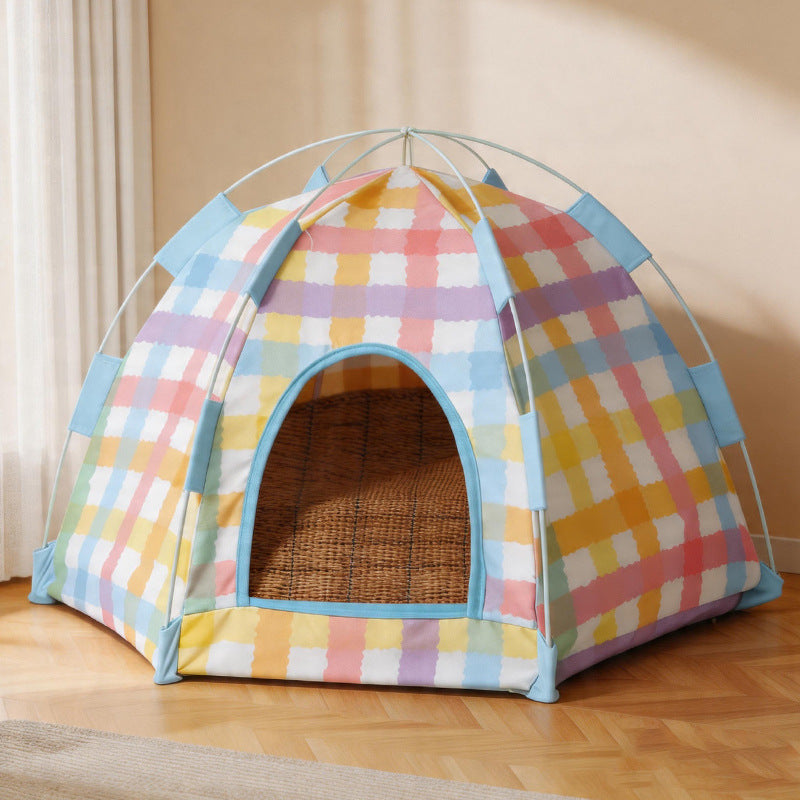 Pastel plaid pop up cat tent bed with a bamboo mat inside on a wooden floor.