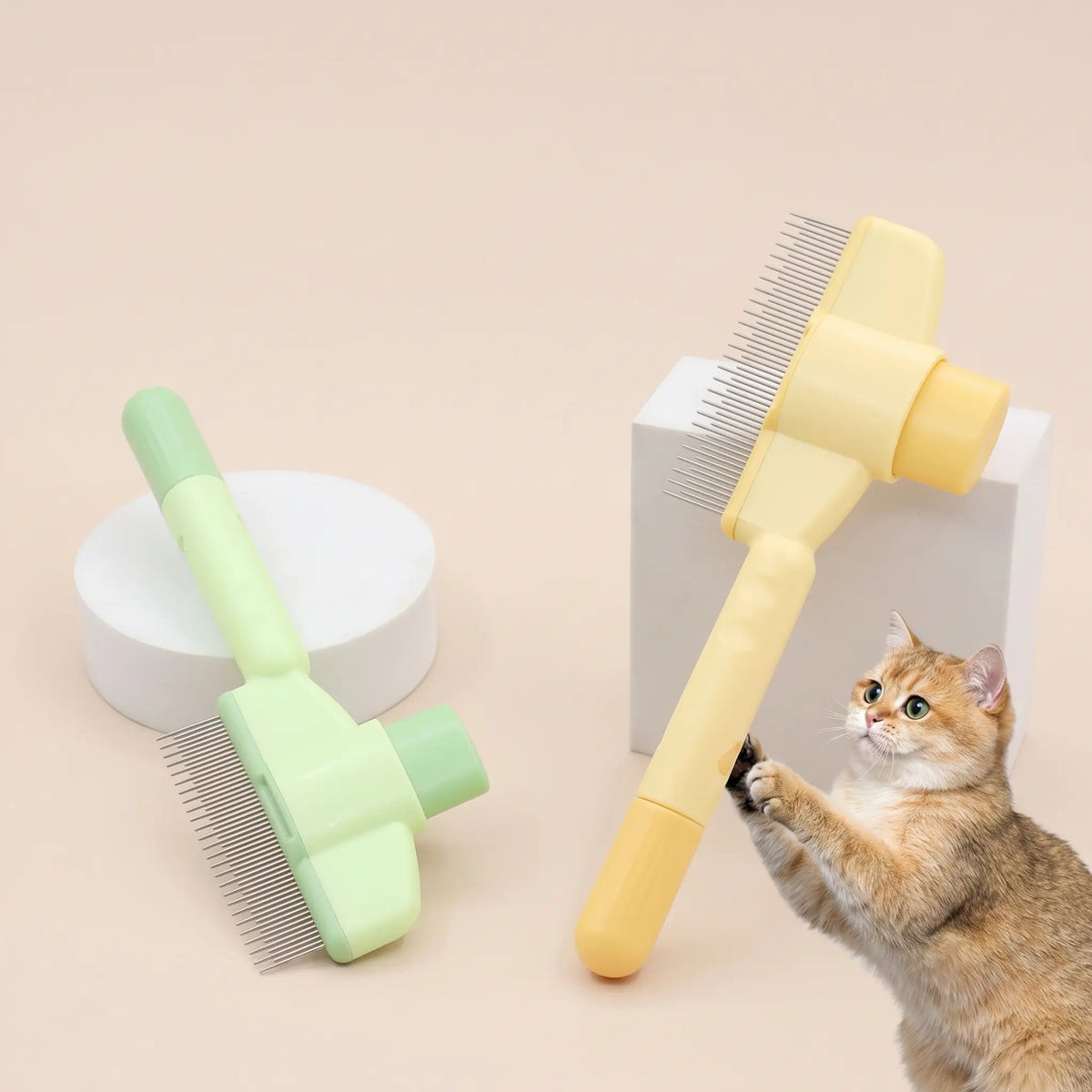 Yellow and green self cleaning cat slicker brushes standing on a beige backdrop with a kitten reaching up.