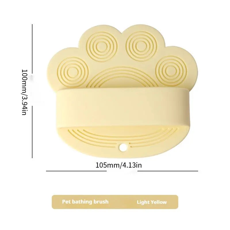 Light yellow silicone dog bath brush with its 105 mm width and 100 mm height marked.
