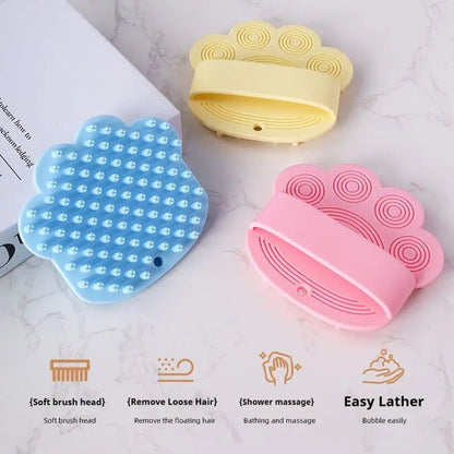 Blue, yellow and pink silicone dog bath brushes on marble with soft brush head, remove loose hair, shower massage and easy lather icons.