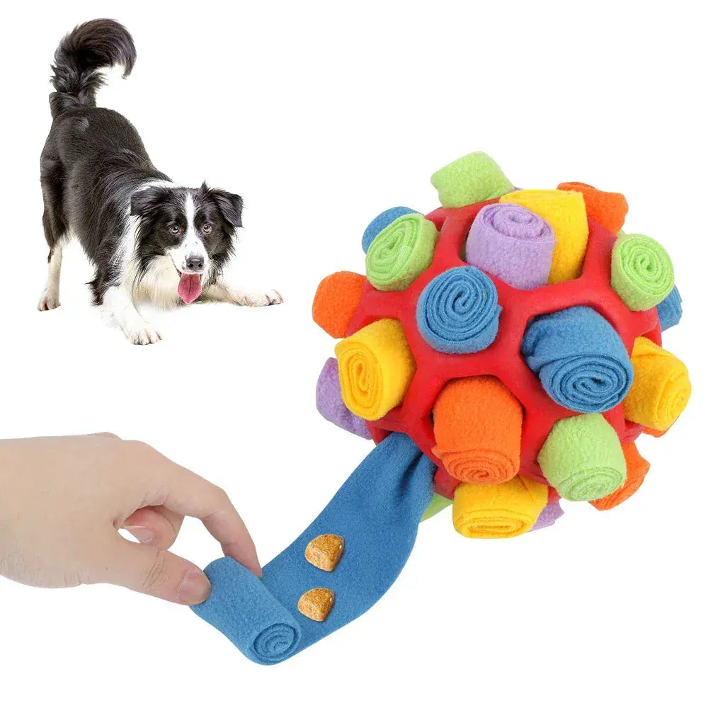 Border collie beside the blue snuffle ball for dogs while a hand pulls one fleece strip out of the rubber core.