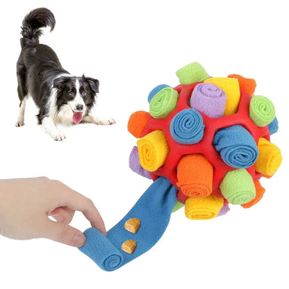 Border collie beside the blue snuffle ball for dogs while a hand pulls one fleece strip out of the rubber core.