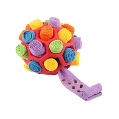 Red snuffle ball for dogs with multicolored fleece strips and one purple strip pulled out.