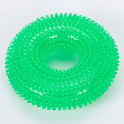 Green spiky dog chew ring on a white background.