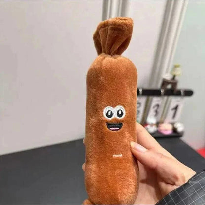 One segment of the squeaky sausage dog toy held in a hand, showing the tied ends and the printed face.