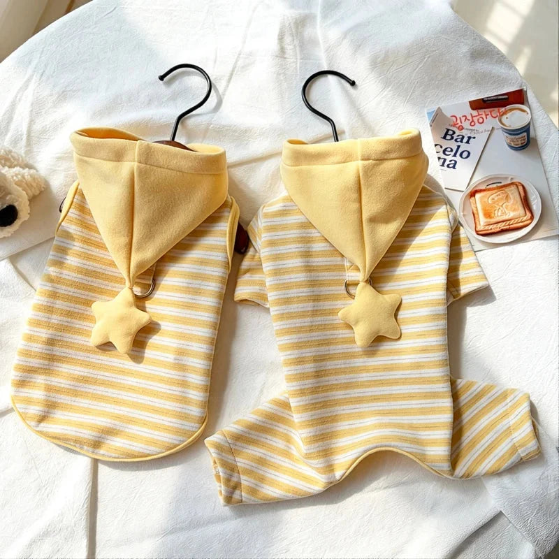 Two yellow striped dog pajamas with star hoods hanging side by side.