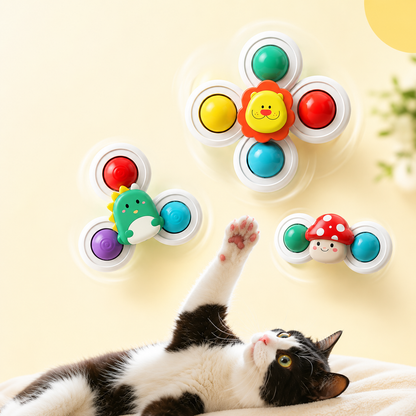 Black and white cat lying on its back reaching up at three Forest Spin Set spinners mounted on a yellow wall