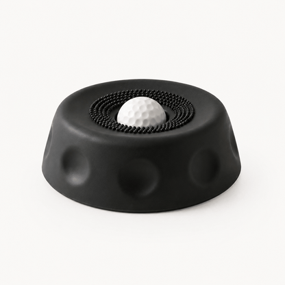 Black suction dog lick bowl with a white rolling ball on a cream background.