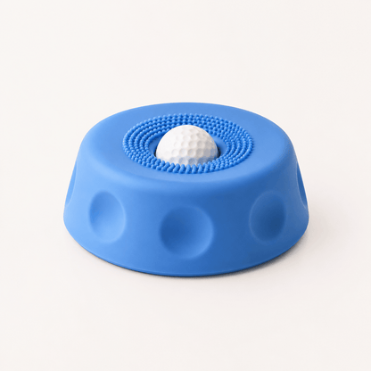 Blue suction dog lick bowl with a white rolling ball on a cream background.
