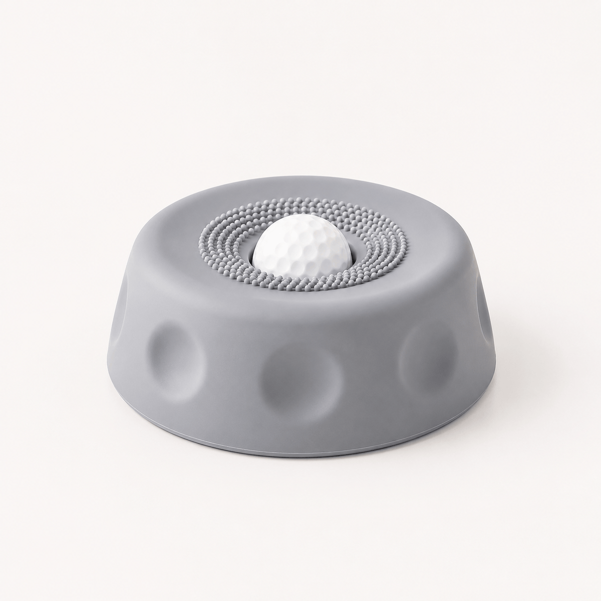 Gray suction dog lick bowl with a white rolling ball on a cream background.