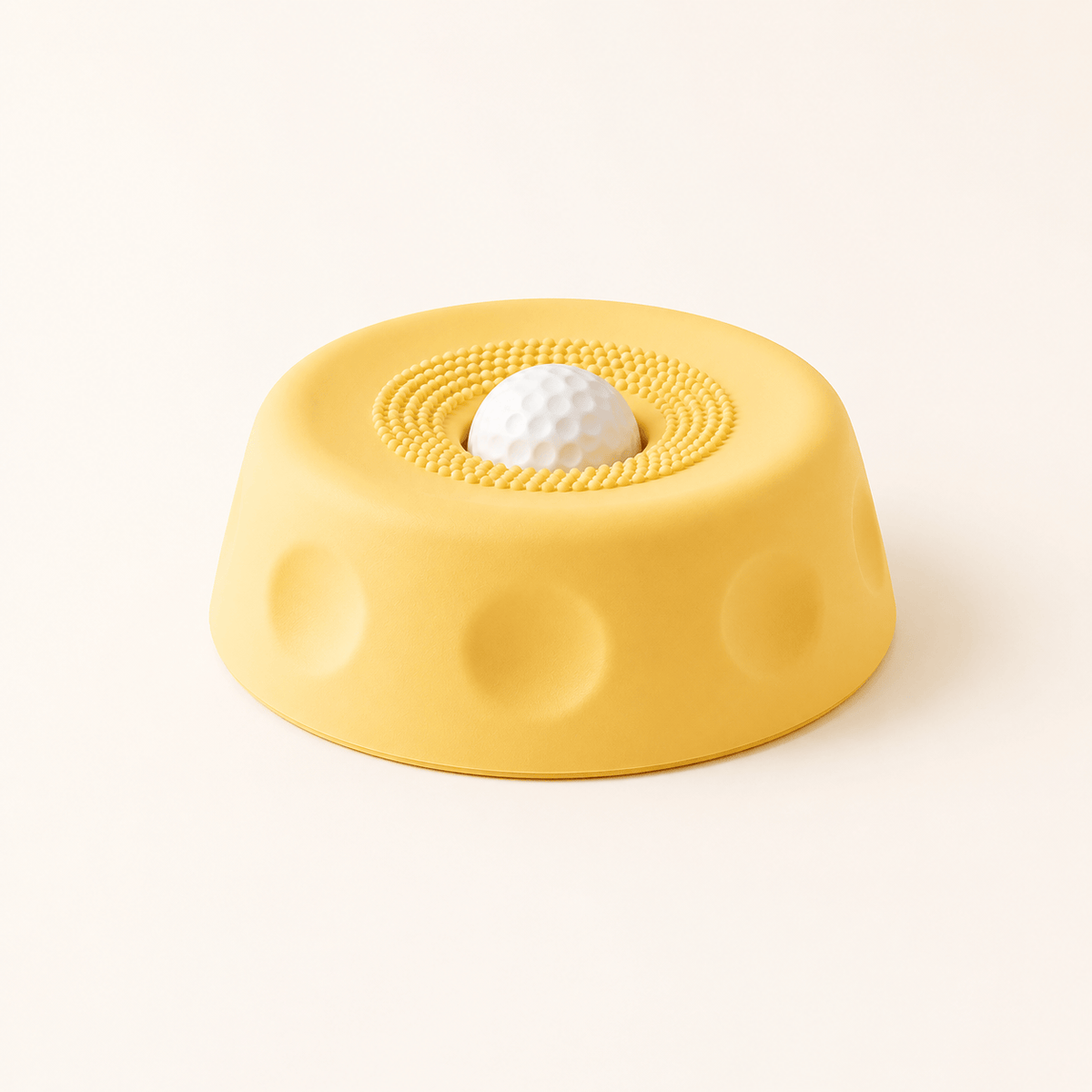 Yellow suction dog lick bowl with a white rolling ball on a cream background.