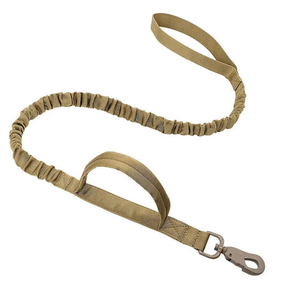 Khaki tactical bungee dog leash with two padded handles and a metal snap hook on a white background.