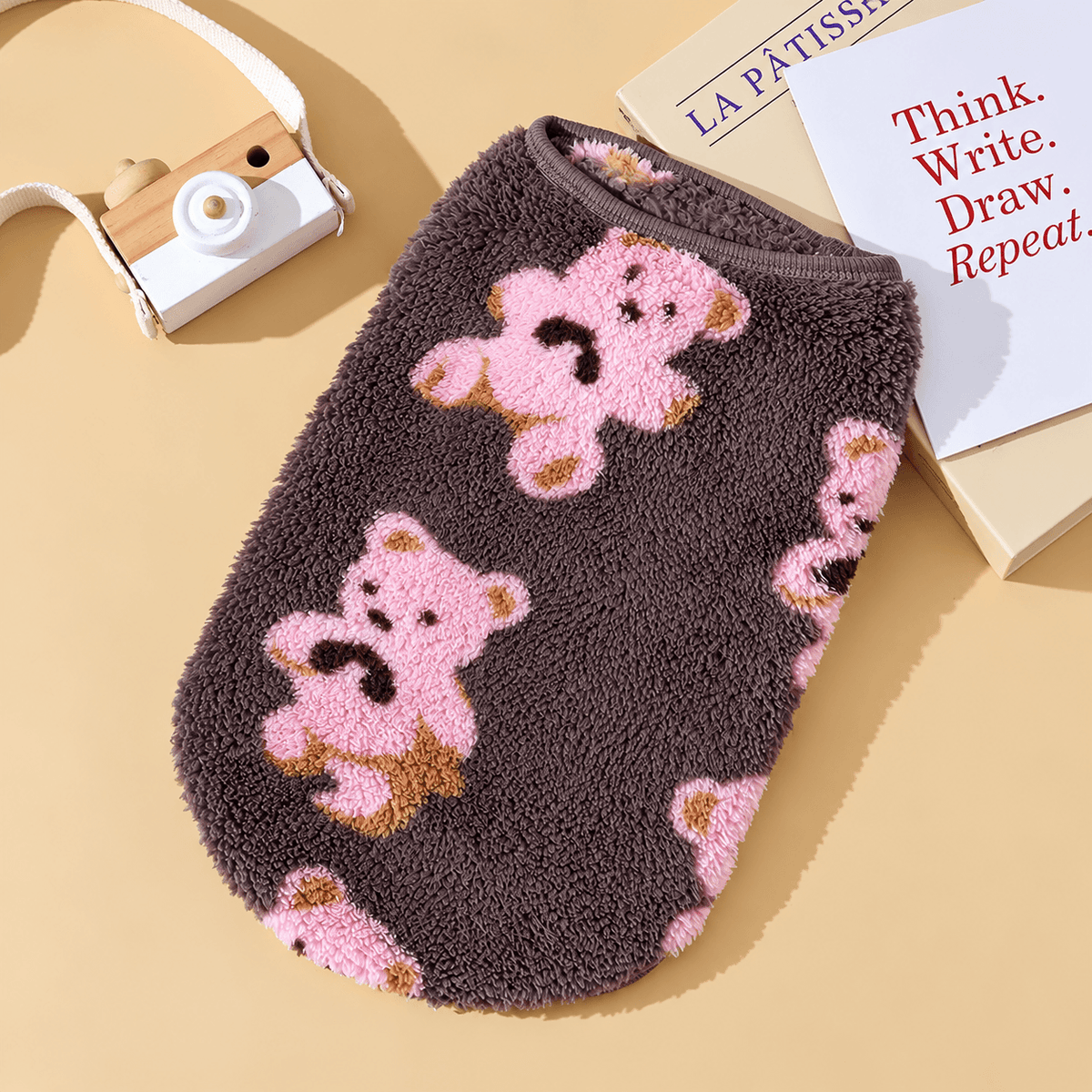 Dark brown teddy bear fleece dog vest with pink bears laid flat.