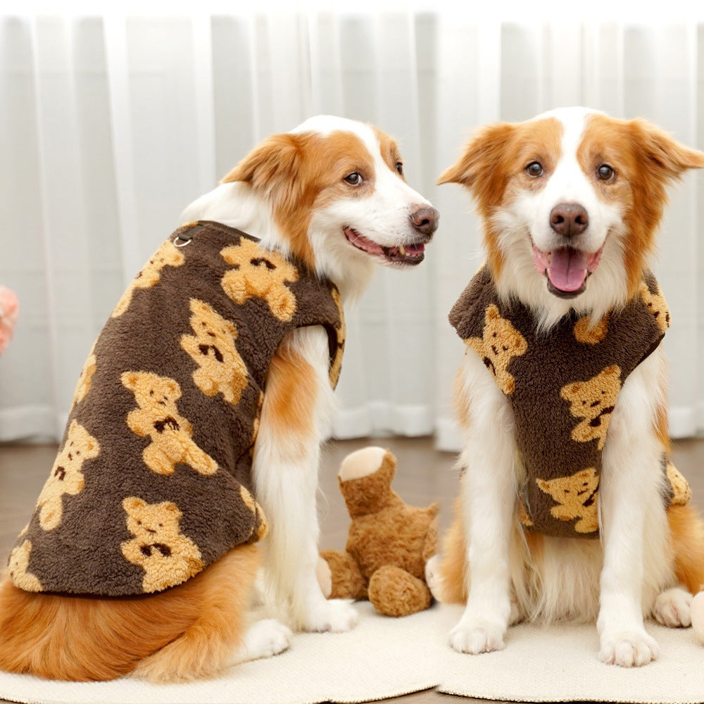 Two smiling dogs sitting indoors wearing the brown teddy bear fleece dog vest.