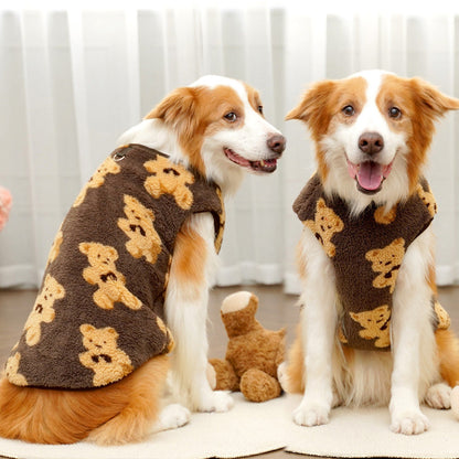 Two smiling dogs sitting indoors wearing the brown teddy bear fleece dog vest.
