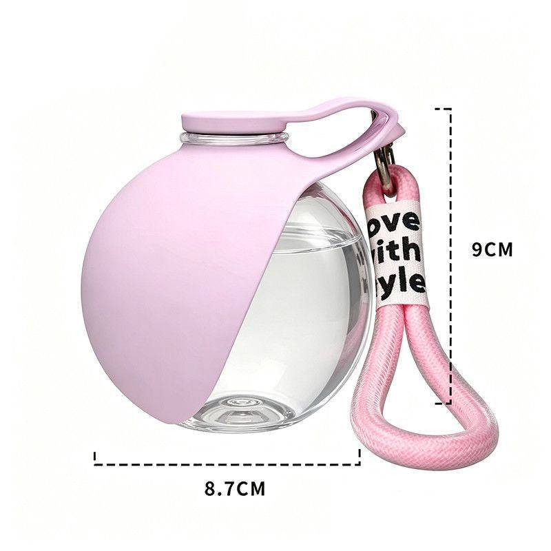 Pink travel dog water bottle with 9 cm height and 8.7 cm width marked and a pink lanyard.