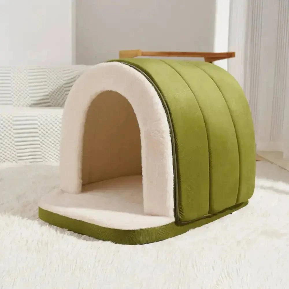 Green enclosed cave bed photographed empty on a white rug.
