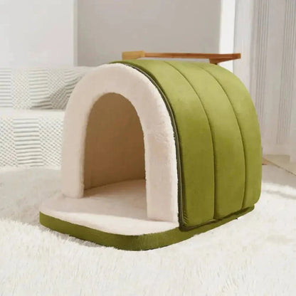 Green enclosed cave bed photographed empty on a white rug.