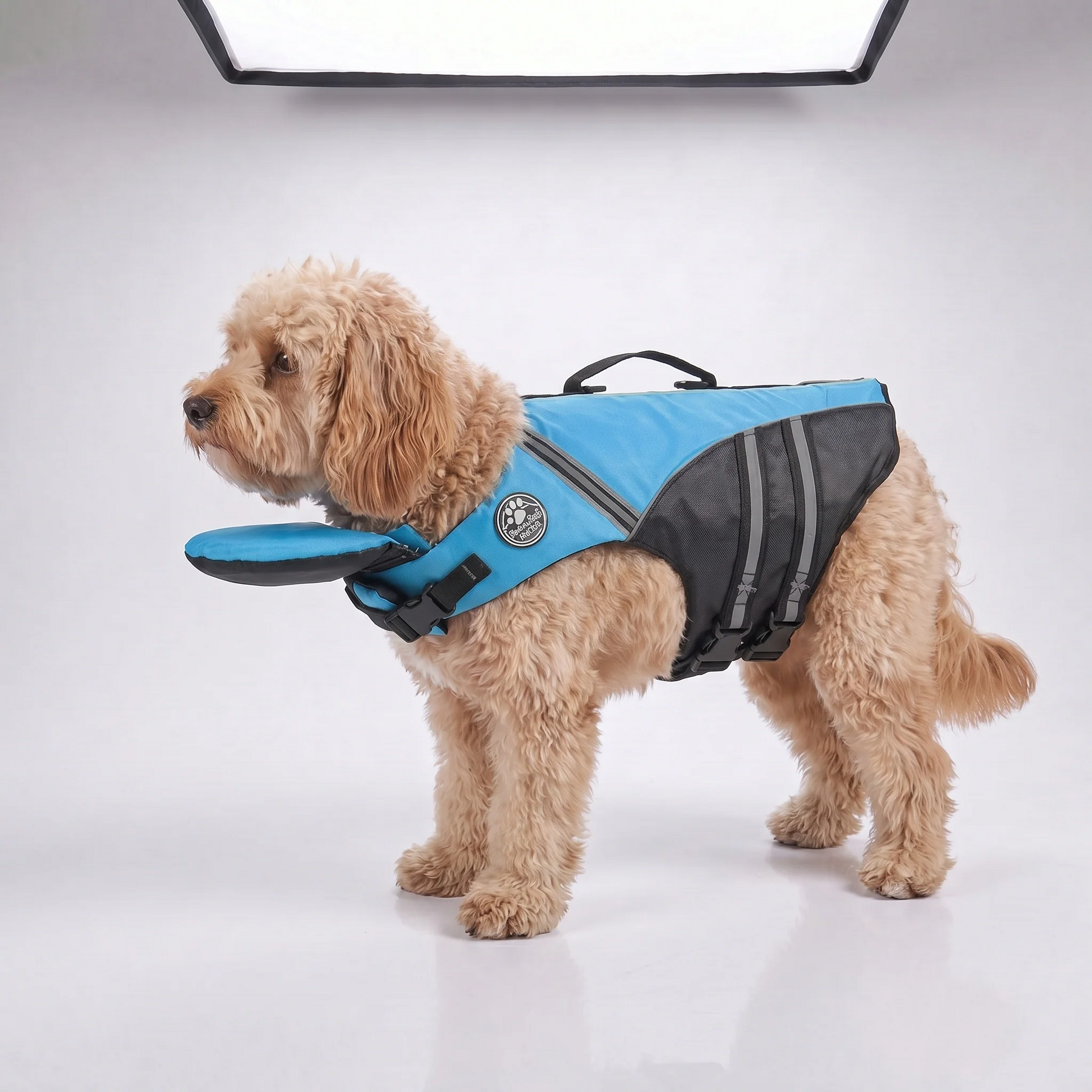 Blue camo dog life jacket with head support, Noblias brand, designed for safety and buoyancy during water activities.